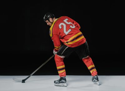 back view of professional sportsman playing ice hockey on black back view of professional sportsman playing ice hockey on black