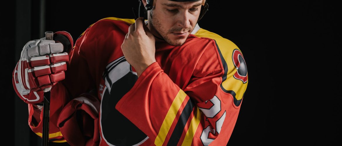 professional adult hockey player holding hockey stick and wearing helmet isolated on black professional adult hockey player holding hockey stick and wearing helmet isolated on black