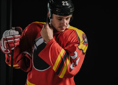 professional adult hockey player holding hockey stick and wearing helmet isolated on black professional adult hockey player holding hockey stick and wearing helmet isolated on black
